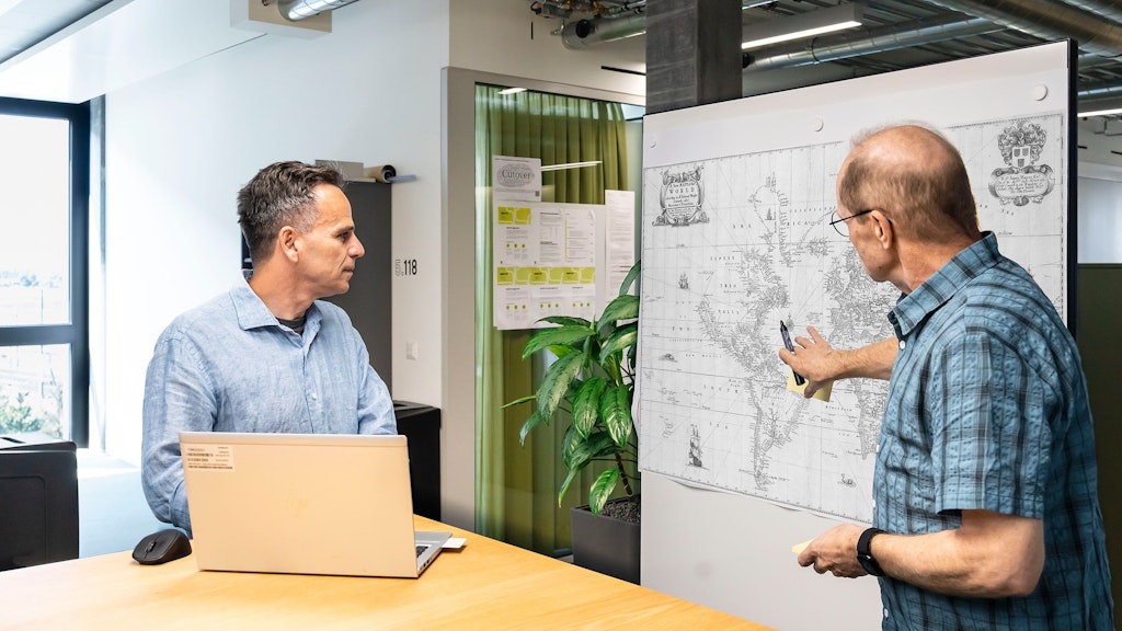 Zwei Personen besprechen Ablauf am Whiteboard