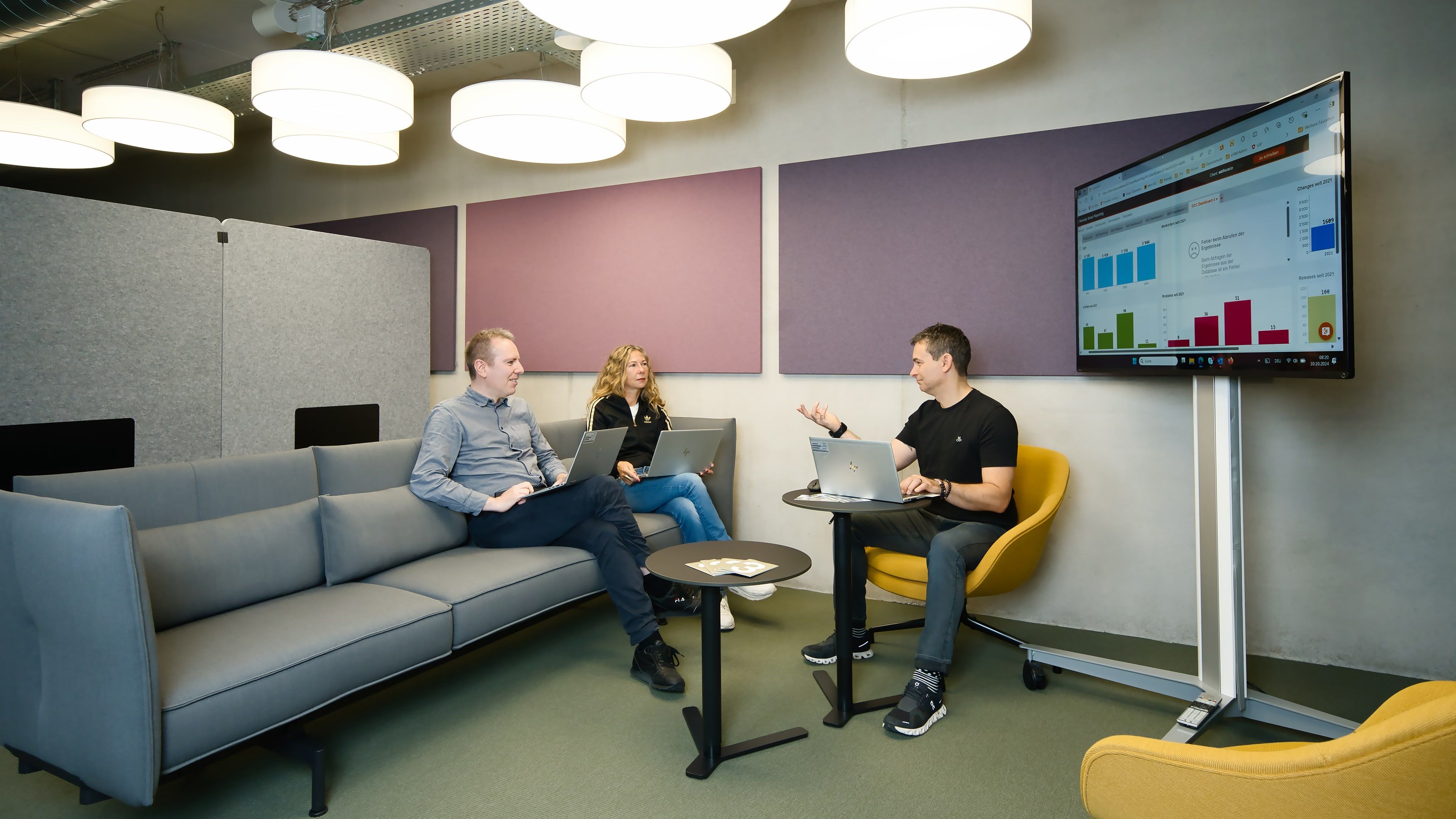 Trois personnes discutent dans un coin salon